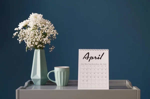 Komposition med kalender, blombukett och kopp på bord mot grå bakgrund — Stockfoto