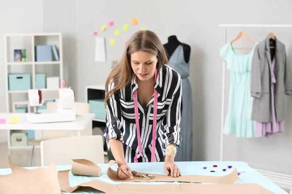 Beautiful female business owner working with sewing patterns in atelier — Stock Photo, Image