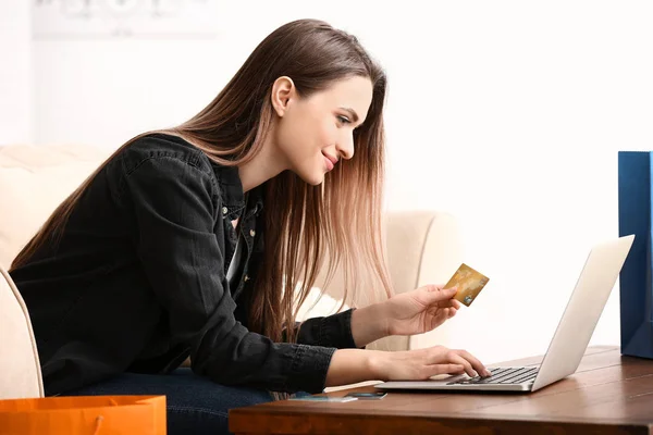 Молода жінка з покупками кредитних карток онлайн вдома — стокове фото