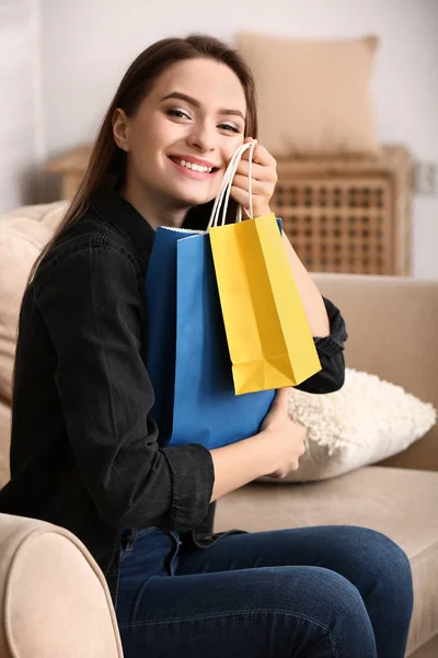 Gelukkige jonge vrouw met boodschappentassen thuis — Stockfoto