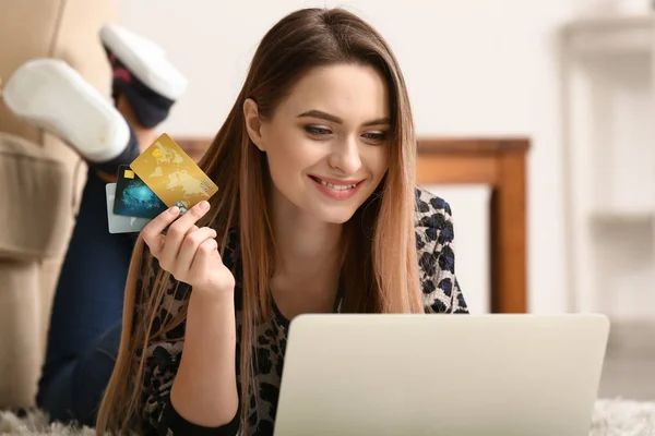 Молода жінка з кредитними картками покупки онлайн вдома — стокове фото