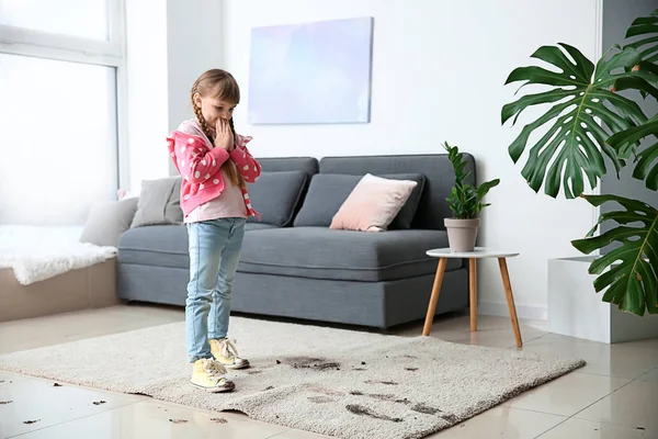 Little girl in muddy shoes messing up carpet at home