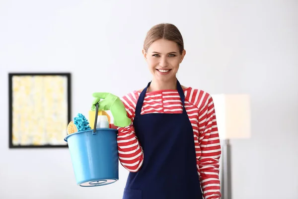 Beautiful woman with cleaning supplies at home — Stock Photo, Image
