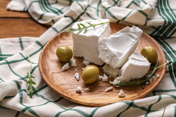 Prato com queijo feta saboroso e azeitonas na mesa — Fotografia de Stock