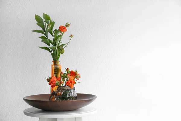 Vasos com belas flores na mesa contra fundo branco — Fotografia de Stock