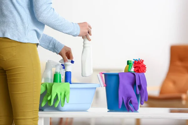 Young woman with cleaning supplies at home — Stock Photo, Image