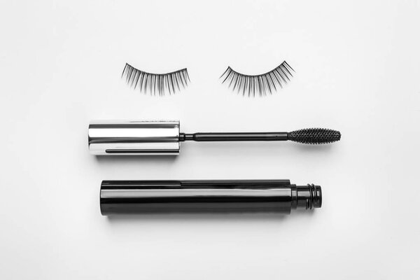 Mascara with false eyelashes on white background