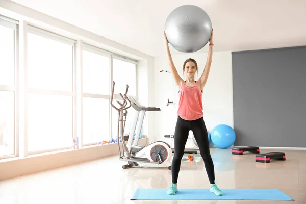 Deportiva joven entrenando con fitball en el gimnasio — Foto de Stock