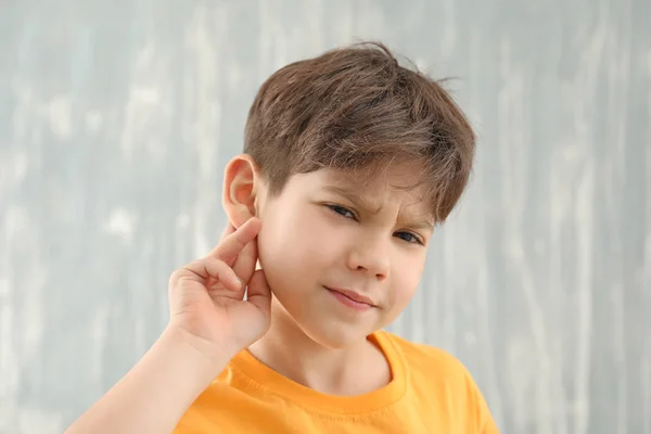 Little boy with hearing problem on grey background — Stock Photo, Image