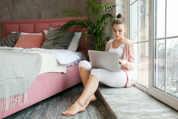 Bella giovane donna con computer portatile a riposo a casa — Foto Stock