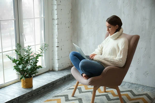 Beautiful young woman with laptop resting at home — Stock Photo, Image