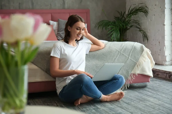 Bella giovane donna con computer portatile a riposo a casa — Foto Stock