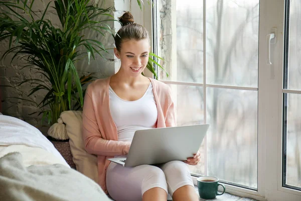 Bella giovane donna con computer portatile a riposo a casa — Foto Stock