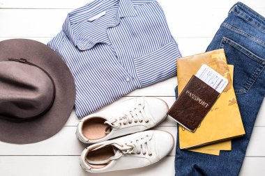 Beyaz ahşap arka planda belgeler ve harita ile giysiler