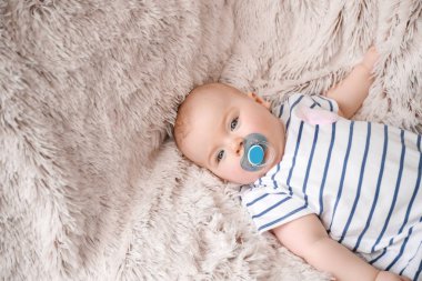 Sevimli bebek kız yumuşak ekose üzerinde yatıyor