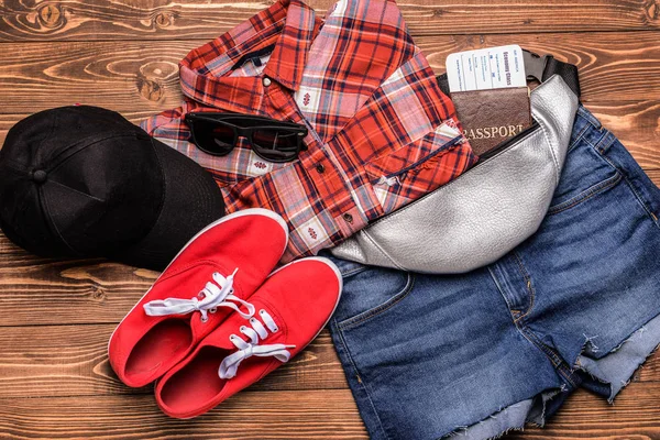 Frauenkleidung mit Dokumenten und Sonnenbrille auf Holzgrund — Stockfoto