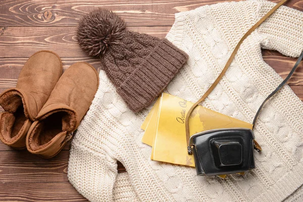 Female clothes with map and photo camera on wooden background — Stock Photo, Image