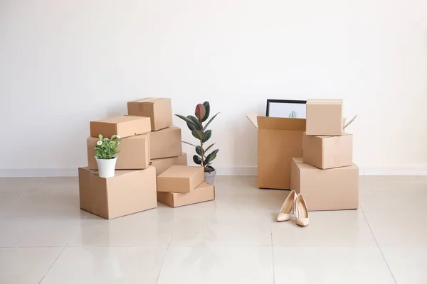 Moving boxes with belongings in empty room — Stock Photo, Image