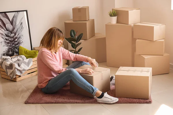 Young woman packing belongings in room — Stock Photo, Image