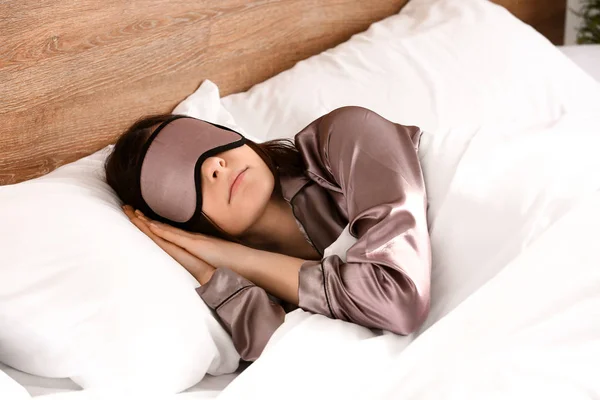 Giovane donna con maschera del sonno a letto — Foto Stock