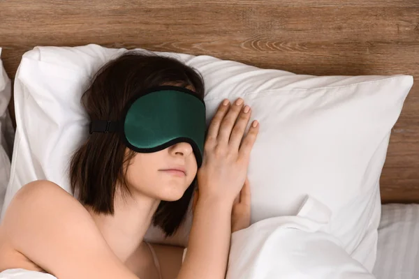 Jeune femme avec masque de sommeil au lit — Photo