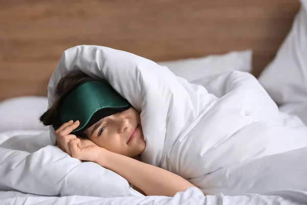 Sleepy young woman with mask in bed — Stock Photo, Image