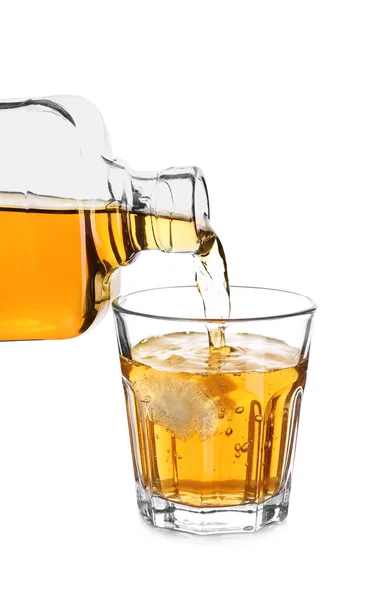 Gieten van whisky uit fles in het glas op witte achtergrond — Stockfoto