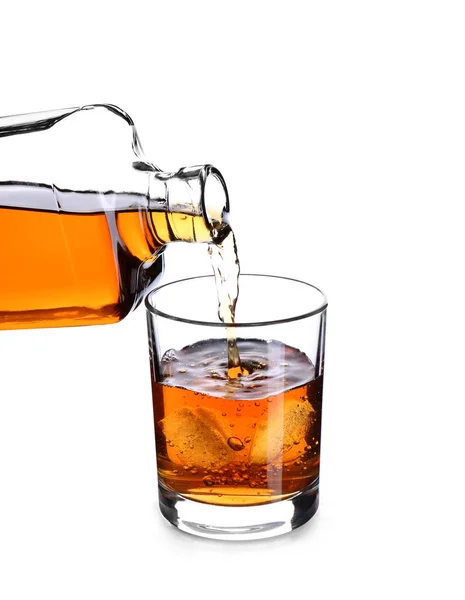 Gieten van whisky uit fles in het glas op witte achtergrond — Stockfoto