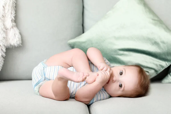 Adorable baby boy lying on soft sofa at home — Stock Photo, Image