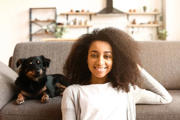 Mulher afro-americana bonita com cão bonito em casa — Fotografia de Stock