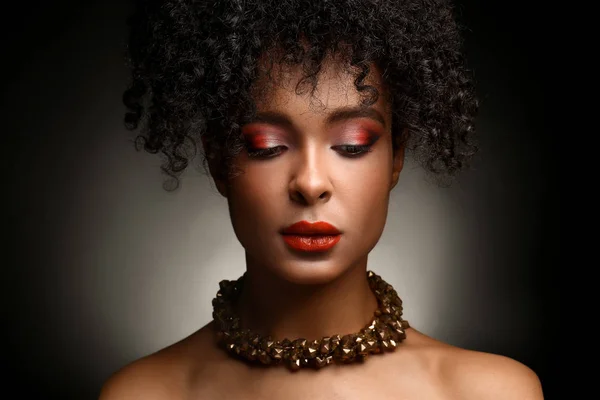 Portrait of beautiful African-American woman on dark background Stock Image