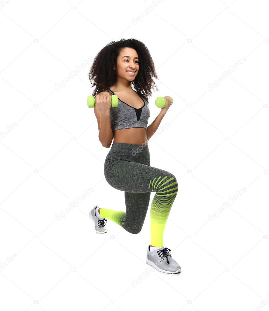 Sporty African-American woman training on white background