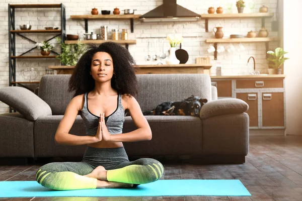 Sporty African-American woman practicing yoga at home — Stock Photo, Image