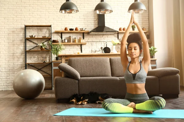 Sporty African-American woman practicing yoga at home — Stock Photo, Image