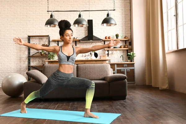 Sporty African-American woman practicing yoga at home — Stock Photo, Image