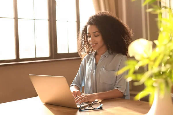 Female African-American freelancer working on laptop at home — Stock Photo, Image