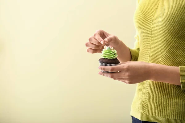 Woman with tasty Easter cupcake on color background, closeup — Stock Photo, Image