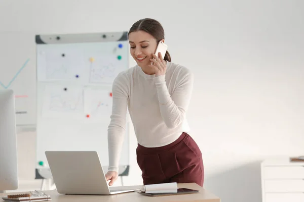 Businesswoman talking by mobile phone in office — Stock Photo, Image