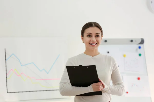 Businesswoman with clipboard in office — Stock Photo, Image