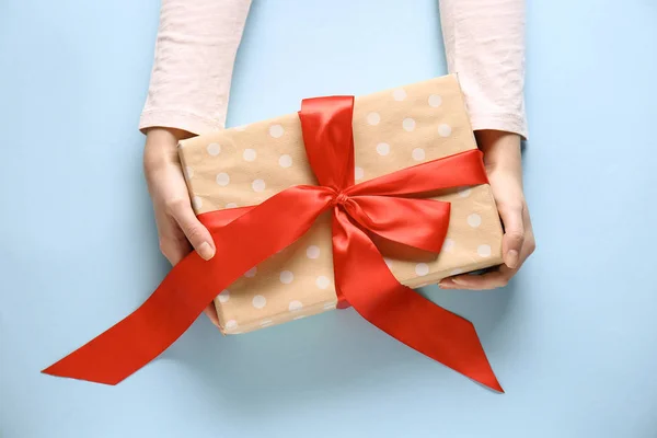 Vrouwelijke handen met geschenkdoos op kleur achtergrond — Stockfoto