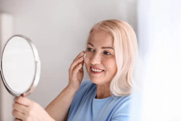 成熟した女性は、自宅で顔のクリームを適用 — ストック写真