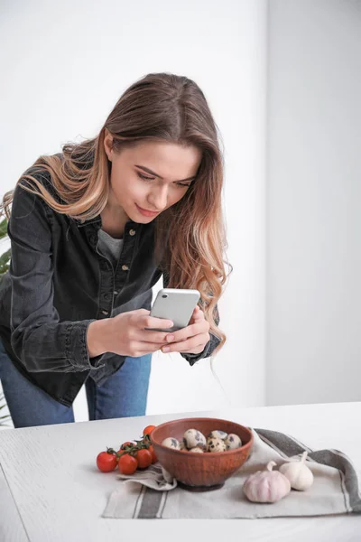 Female food photographer with mobile phone taking picture of tasty food at home — Stock Photo, Image