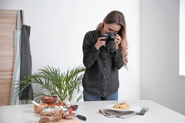 Female food photographer working in home studio