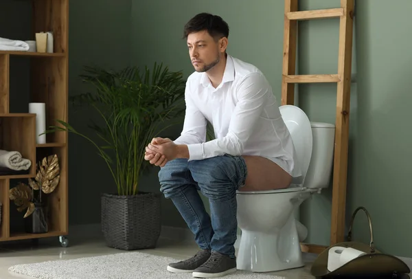 Man sitter på toalettstolen hemma — Stockfoto