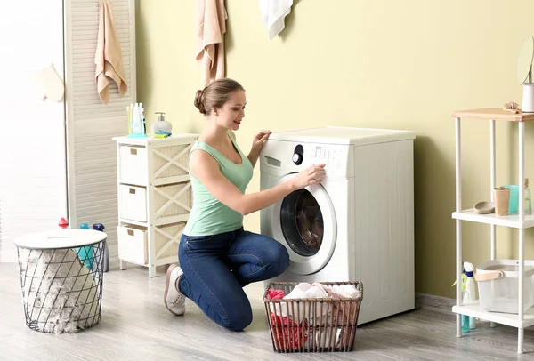 Jeune femme faisant la lessive à la maison — Photo