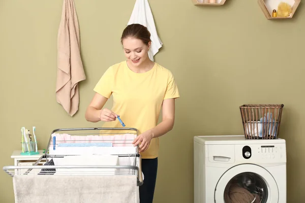 年轻女子洗完衣服后把衣服挂在干衣机上 — 图库照片