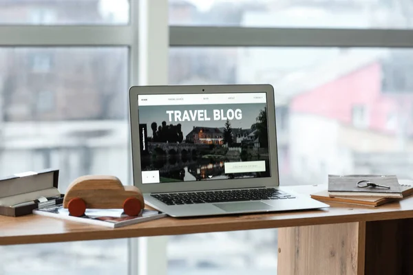 Laptop with open page of travel blog on table — Stock Photo, Image