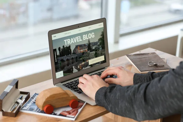 Male travel blogger working on laptop at table — Stock Photo, Image