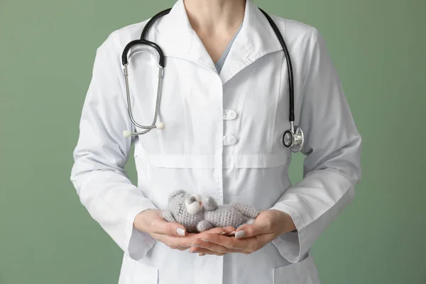 Pediatrician with toy on color background — Stock Photo, Image