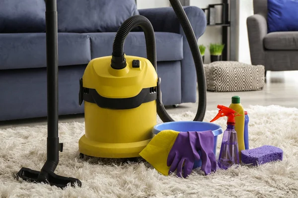 Reinigungsmittel mit Staubsauger auf weichem Teppich im Zimmer — Stockfoto